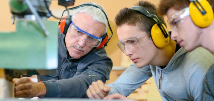 Three people working with machinery